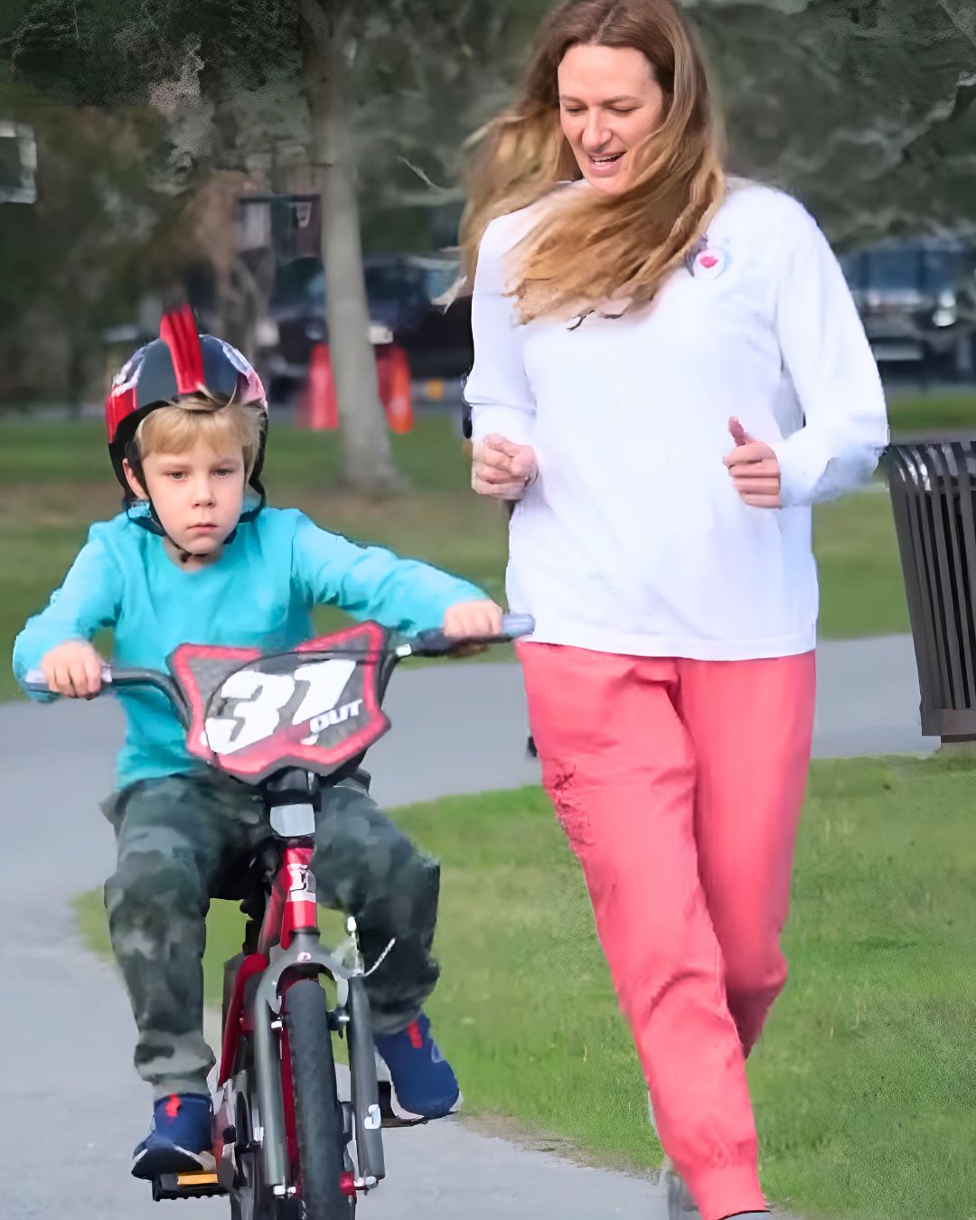 A person is running with a child on a bike